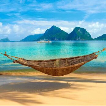 Hammock on the ocean in front of mountains 